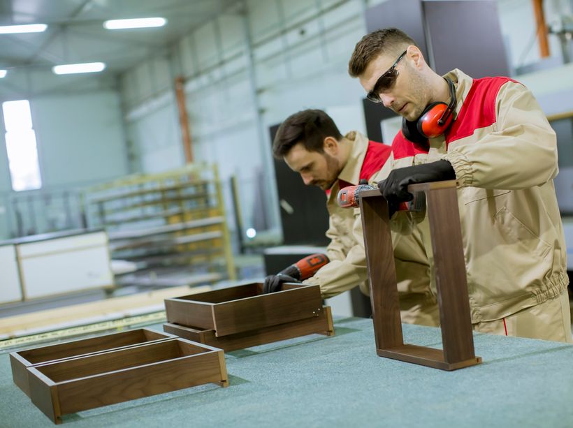Dos trabajadores montando muebles