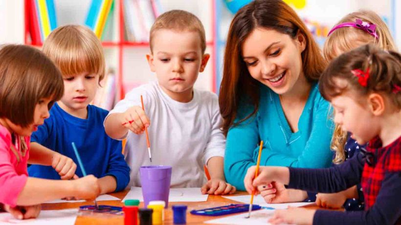 Un educadora infantil junto a un grupo de niñas y niños