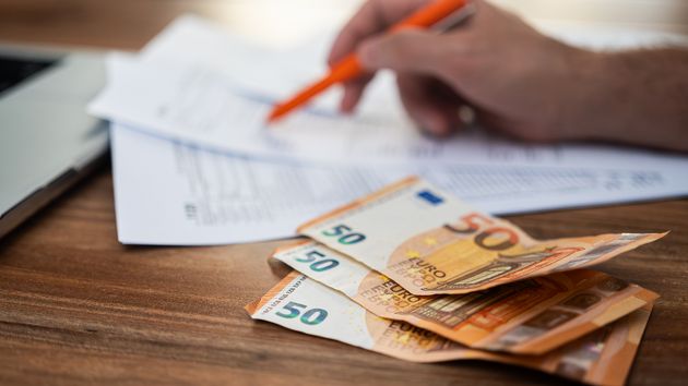 Solicitud junto a varios billetes de euro