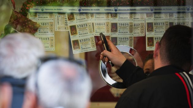 Décimos de la Lotería de Navidad expuestos en una administración con diferentes números y terminaciones