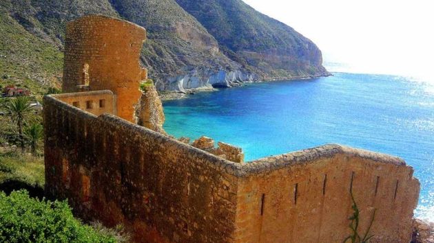 La última cala ‘hippie’ de España: una playa virgen de aguas turquesas rodeada por una fortaleza medieval
