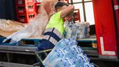Un repartidor cargado de botellas de agua