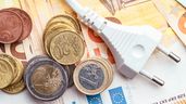 Billetes con monedas y enchufe