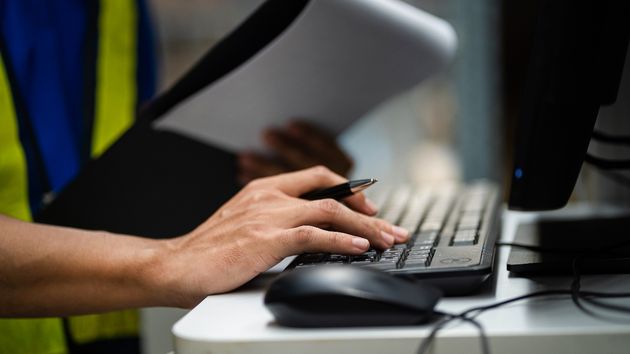 Un trabajador escribiendo en el ordenador