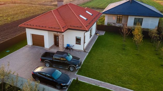 Dos coches aparcados en la parcela de una vivienda 