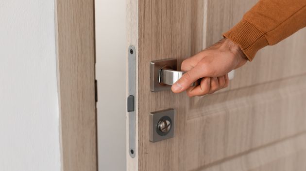Una persona abriendo la puerta de una casa