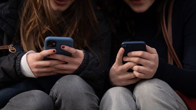 Dos personas usan el teléfono móvil