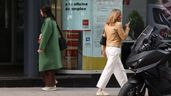 Dos personas pasando por delante de una oficina de empleo