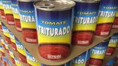 unas latas de tomate triturado en un supermercado
