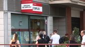 Varias personas esperando en la puerta de una oficina de empleo