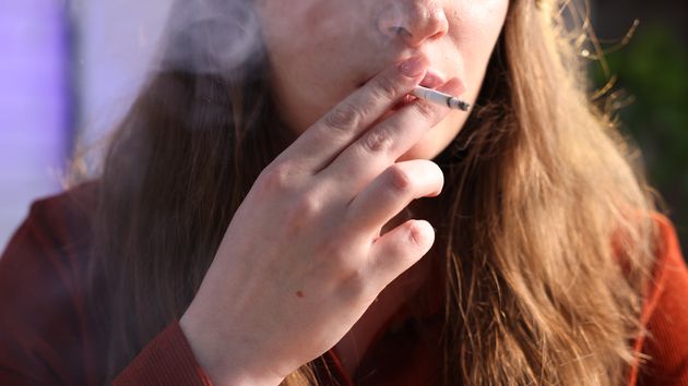 Mujer fumando en la calle