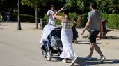 Varias personas pasean con un carrito de bebé
