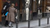 Una persona con discapacidad visual camina acompañada por la calle