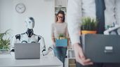 Empleados con cajas al lado de un robot
