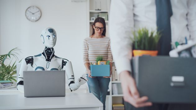 Empleados con cajas al lado de un robot