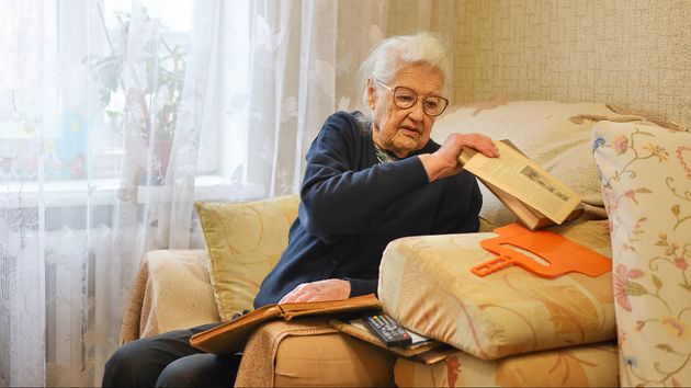 Imagen representativa de una anciana en el salón de su casa