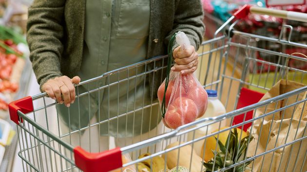 Mujer colocando comida en el carro compra
