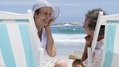 Dos mayores en la playa escuchando música