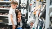 un niño aleatorio y su madre mirando unos zapatos