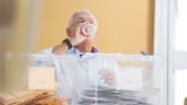Persona mayor hace de presidente en una mesa electoral