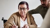 Una mujer firmando un documento 