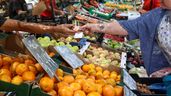 Mujer pagando puesto mercado