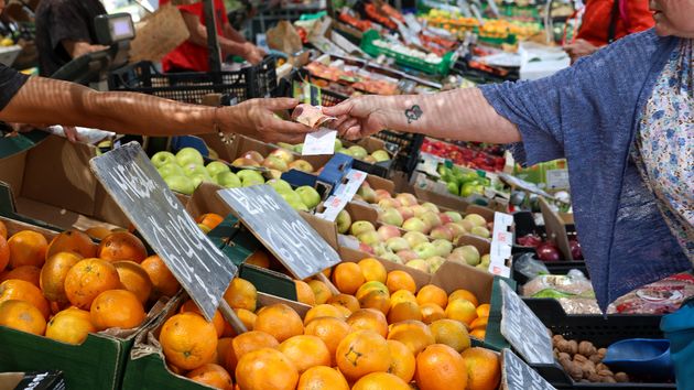 Mujer pagando puesto mercado