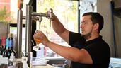 un camarero sirviendo una cerveza