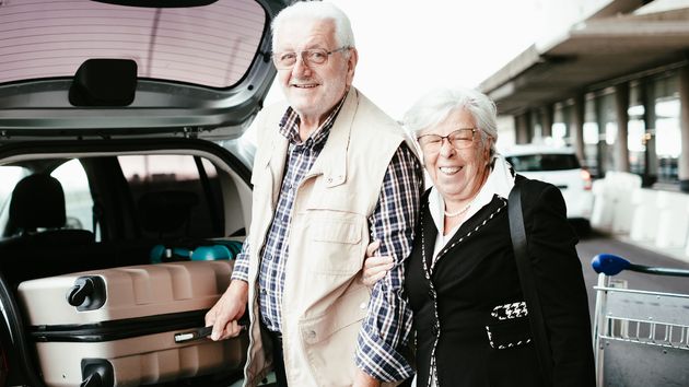 Pareja de sénior cargando maletero del coche