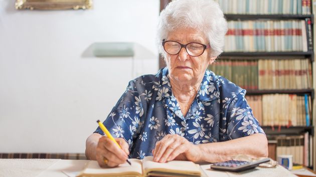 Una anciana firmando un documento 