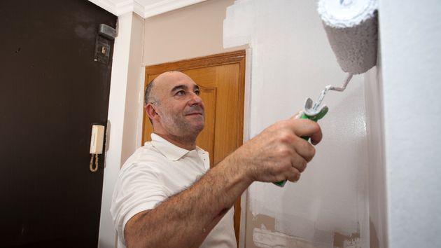 Un hombre pintando una vivienda 