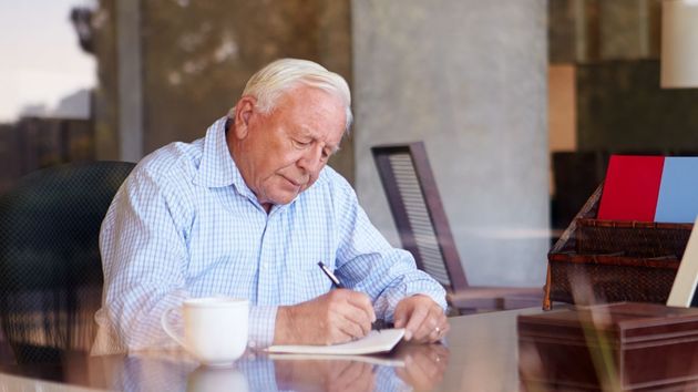 Un anciano firmando un documento 