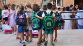 Varios niños de Infantil y Primaria entrando a clase