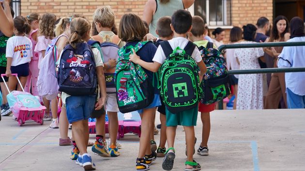 Varios niños de Infantil y Primaria entrando a clase