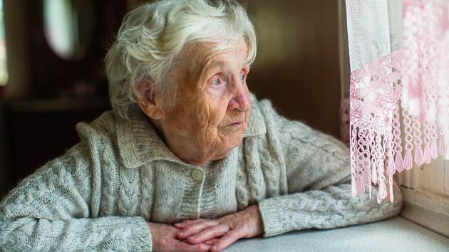 Una anciana mirando por una ventana 