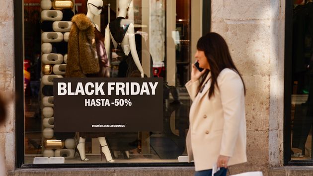 Mujer pasando por delante tienda Black Friday