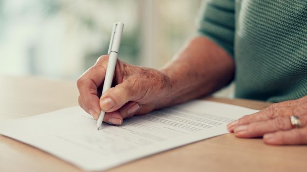 Una persona firmando un documento 
