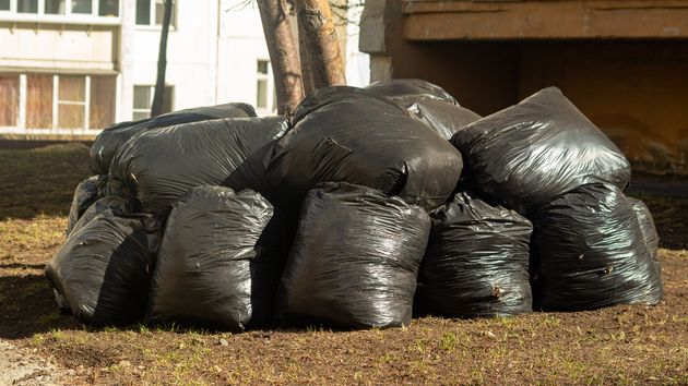 Bolsas de basura acumuladas en un jardín