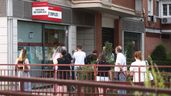 Un grupo de personas hace cola en la puerta de una oficina de empleo