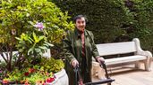 Una anciana delante de un jardín