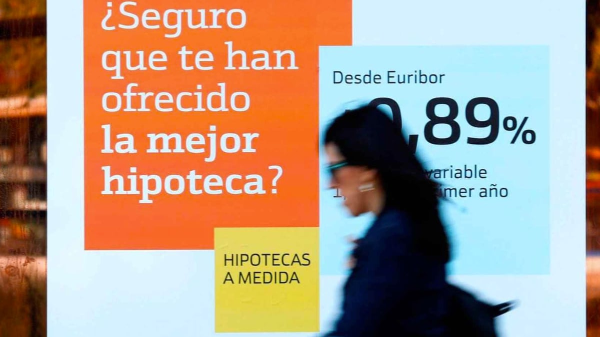 una mujer pasa por una sucursal bancaria