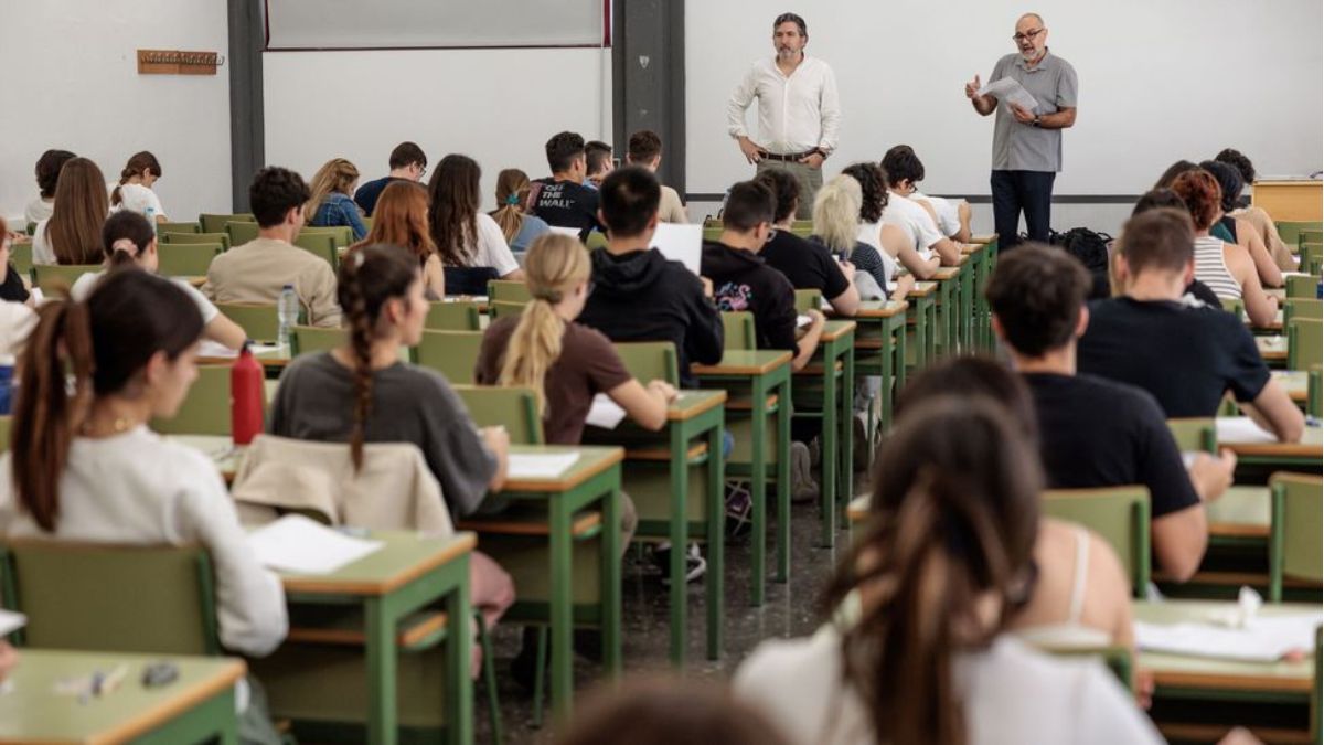 Dos profesores imparten clase en un aula universitaria.