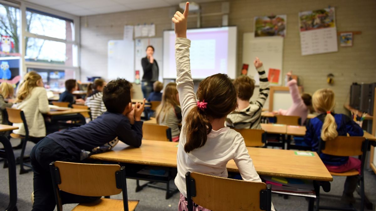 Una maestra imparte clase en un colegio.