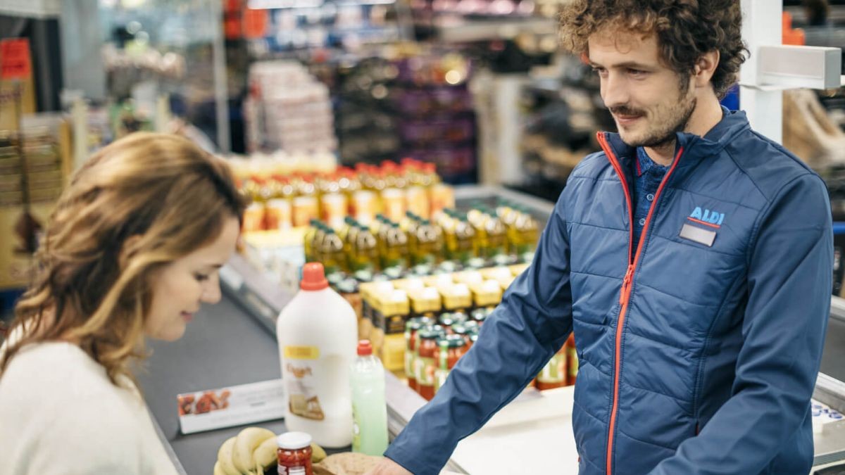 Un trabajador de Aldi atiende en cajas.