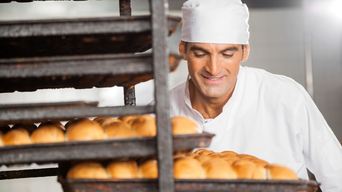 Un pastelero saca el pan del horno