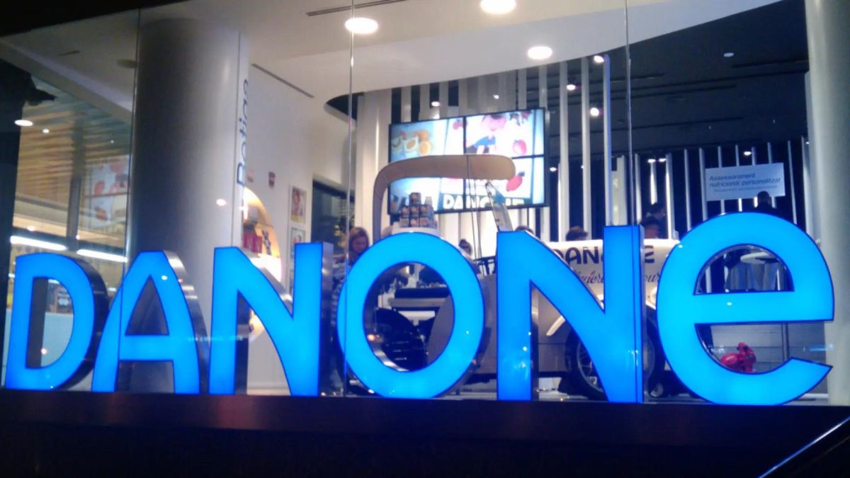 Oficinas de Danone, con varios trabajadores tras el cartel.