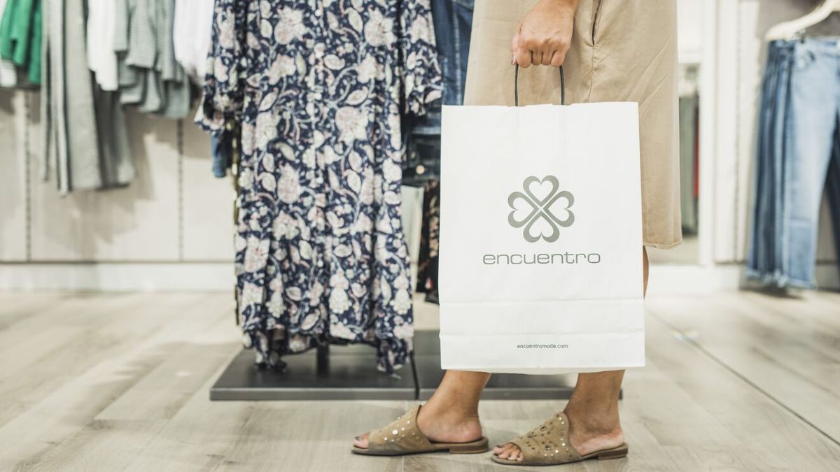 Una clienta abandona la tienda con una bolsa.