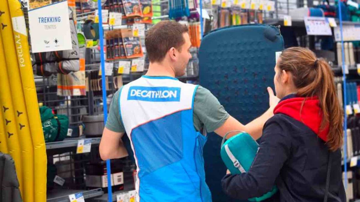 Empleo en Decathlon: un trabajador atiende a una clienta.