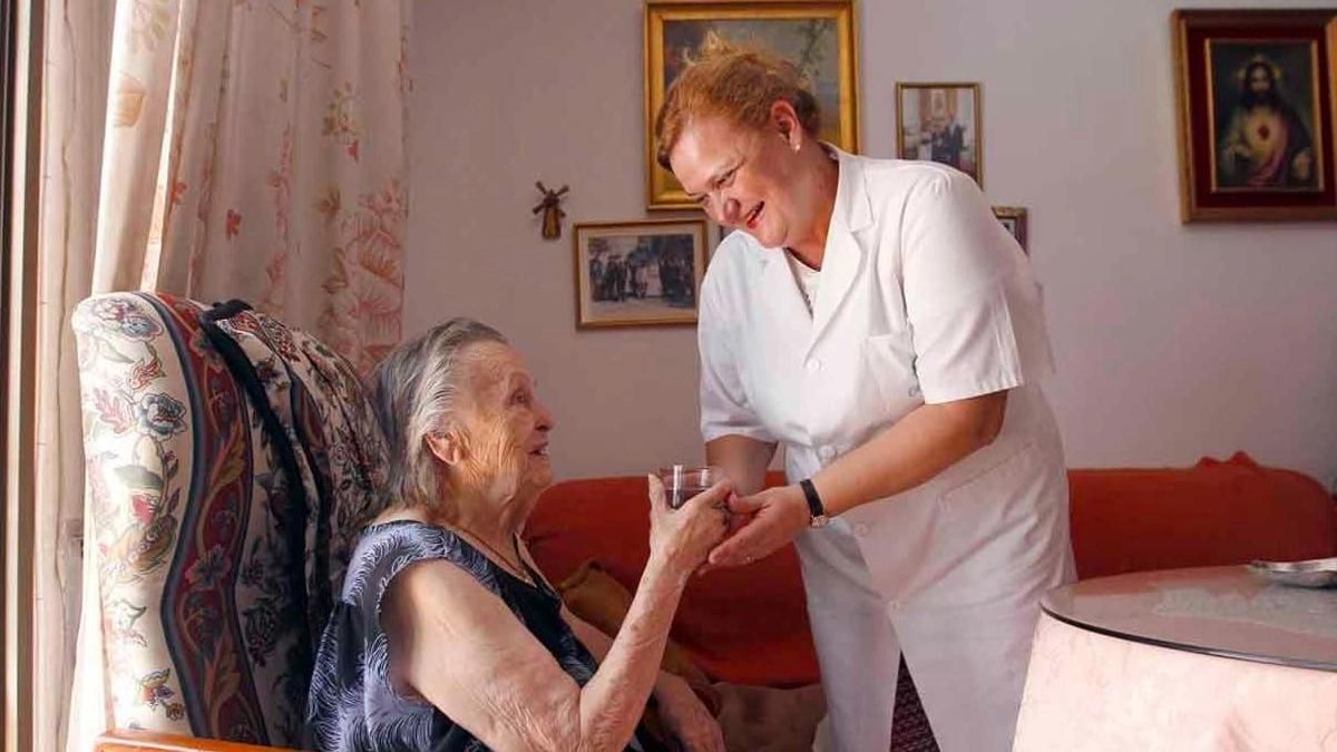 Una trabajadora con una persona mayor.
