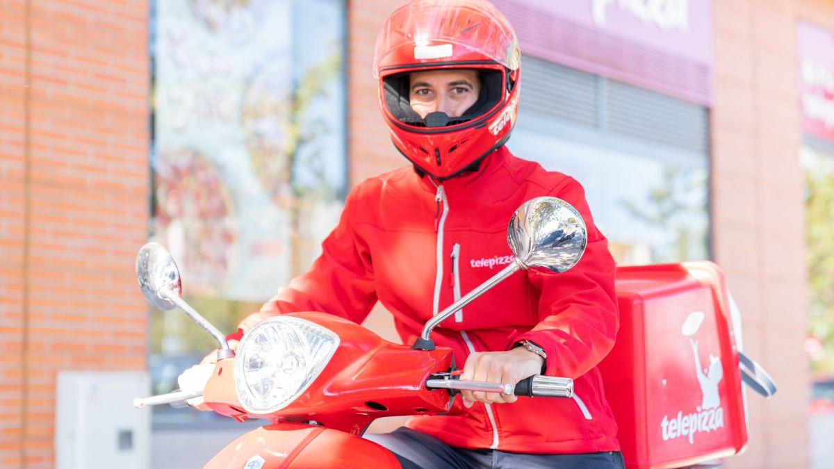 Un joven repartidor de Telepizza subido en su moto.